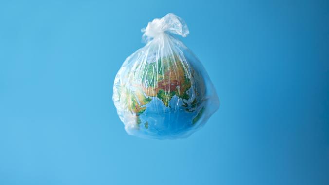 A globe in a plastic bag on a sky blue background.